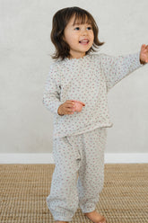 Toddler girl in Avauma Mayrose Oat pajama set – long sleeve floral top and matching pants